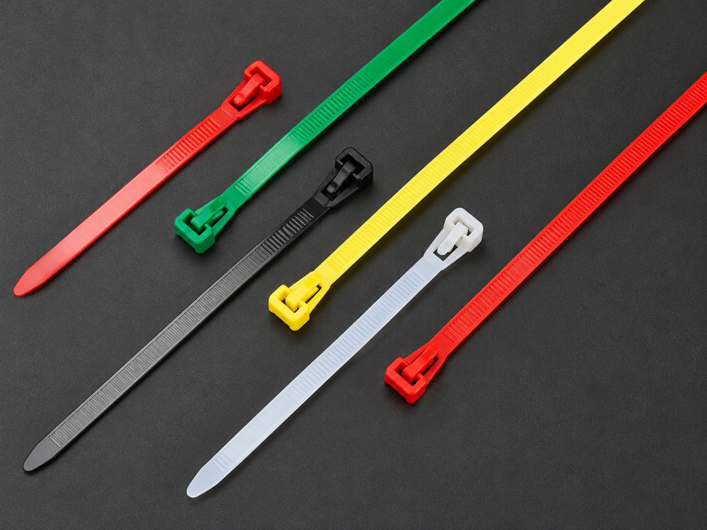 Releasable nylon cable ties with visible release tabs, serrated straps and tapered ends